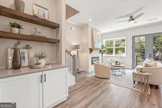 947 Willingham Dr Unit 2, Hapeville, GA 30354 - living room with light wood-type flooring, ceiling fan, a fireplace, crown molding, and stairs