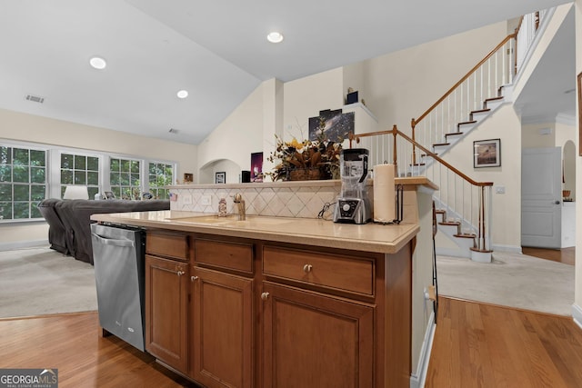 7769 Copper Kettle Way, Flowery Branch, GA 30542 - kitchen with stainless steel dishwasher, light countertops, light wood-type flooring, open floor plan, and recessed lighting