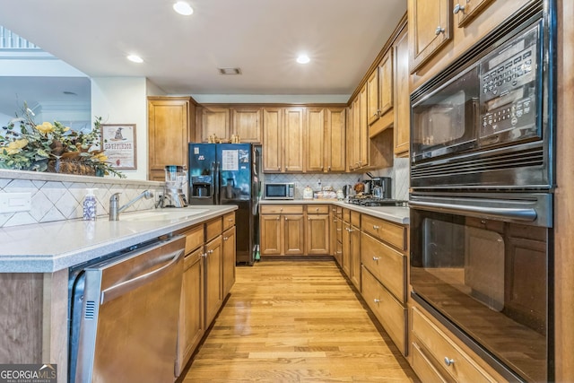 7769 Copper Kettle Way, Flowery Branch, GA 30542 - kitchen with black appliances, light wood-style floors, decorative backsplash, light countertops, and brown cabinets