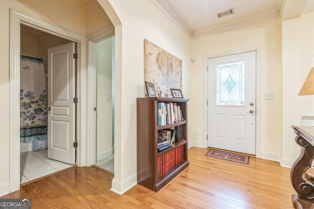 7769 Copper Kettle Way, Flowery Branch, GA 30542 - foyer entrance with arched walkways, light wood-style floors, and crown molding