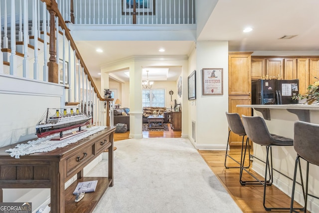 7769 Copper Kettle Way, Flowery Branch, GA 30542 - kitchen featuring freestanding refrigerator, a breakfast bar, a chandelier, light wood-style floors, and recessed lighting