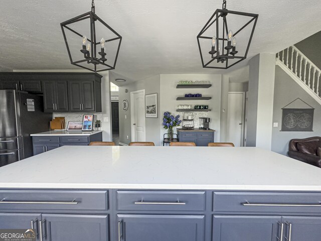 184 Fashion Xing, Mcdonough, GA 30252 - kitchen featuring a chandelier, freestanding refrigerator, and decorative light fixtures