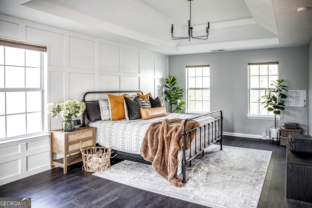 184 Fashion Xing, Mcdonough, GA 30252 - bedroom with a raised ceiling, a decorative wall, a chandelier, and dark wood finished floors