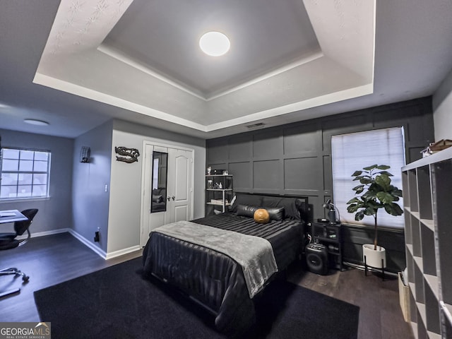 184 Fashion Xing, Mcdonough, GA 30252 - bedroom featuring a tray ceiling and dark wood-type flooring