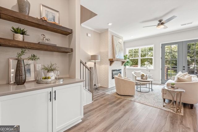 937 Willingham Dr Unit 7, Hapeville, GA 30354 - living room with light wood-type flooring, ceiling fan, a fireplace, crown molding, and stairs