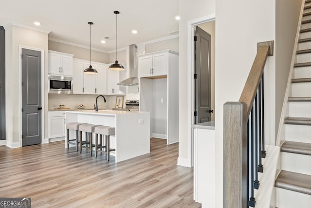 937 Willingham Dr Unit 7, Hapeville, GA 30354 - kitchen with stainless steel appliances, wall chimney range hood, white cabinetry, backsplash, and crown molding