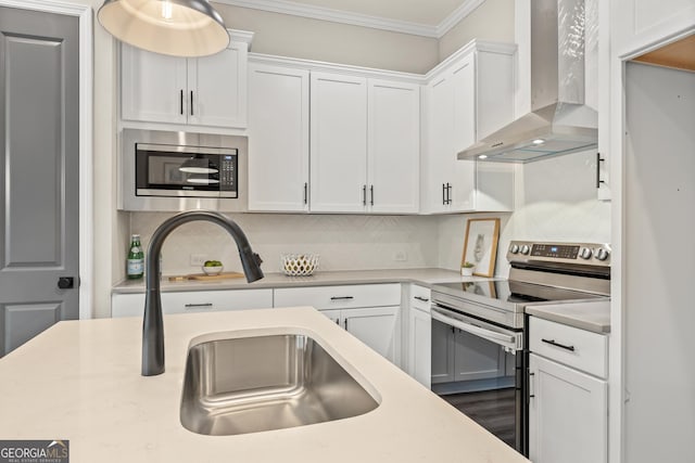 937 Willingham Dr Unit 7, Hapeville, GA 30354 - kitchen featuring wall chimney exhaust hood, stainless steel appliances, white cabinets, ornamental molding, and light countertops