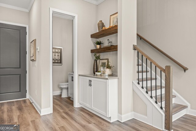 937 Willingham Dr Unit 7, Hapeville, GA 30354 - bar featuring light wood-type flooring, crown molding, and stairs