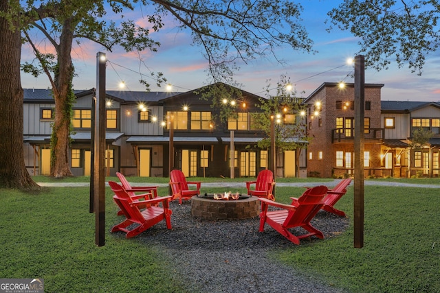 927 Willingham Dr Unit 12, Hapeville, GA 30354 - back of property at dusk featuring an outdoor fire pit, a lawn, and board and batten siding