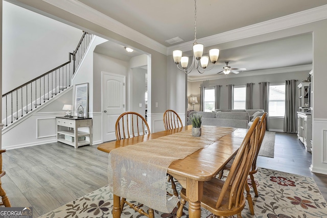 17 October Ave, Newnan, GA 30265 - dining space with wood finished floors, crown molding, wainscoting, a chandelier, and stairway