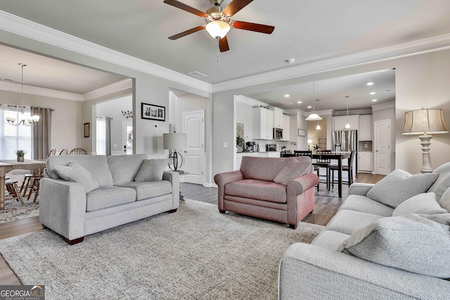 17 October Ave, Newnan, GA 30265 - living area featuring wood finished floors, a ceiling fan, a chandelier, crown molding, and recessed lighting