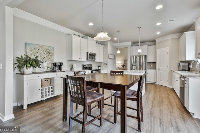 17 October Ave, Newnan, GA 30265 - kitchen with stainless steel appliances, ornamental molding, recessed lighting, tasteful backsplash, and white cabinets