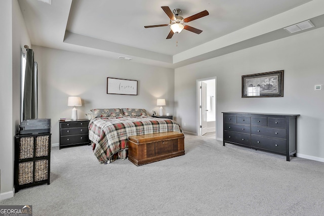 17 October Ave, Newnan, GA 30265 - carpeted bedroom featuring a tray ceiling, ceiling fan, and connected bathroom