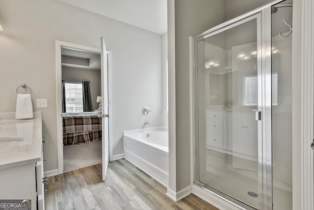 17 October Ave, Newnan, GA 30265 - ensuite bathroom featuring wood finished floors, a garden tub, a stall shower, and vanity