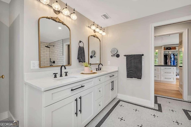 106 Draughons Dr, Saint Simons, GA 31522 - bathroom featuring double vanity, a spacious closet, and tiled shower