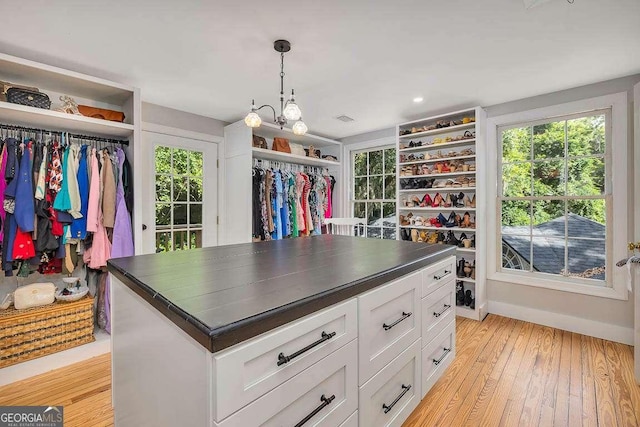106 Draughons Dr, Saint Simons, GA 31522 - spacious closet with a chandelier and light wood-style floors