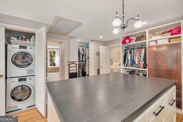 106 Draughons Dr, Saint Simons, GA 31522 - washroom with attic access, estacked washer and dryer, recessed lighting, a chandelier, and light wood-type flooring