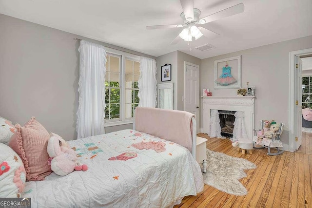 106 Draughons Dr, Saint Simons, GA 31522 - bedroom featuring wood finished floors, a fireplace, and a ceiling fan
