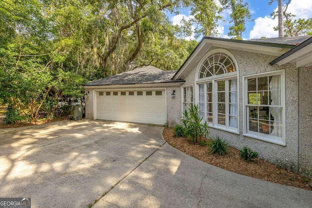 106 Draughons Dr, Saint Simons, GA 31522 - view of side of home with concrete driveway, a garage, and stucco siding