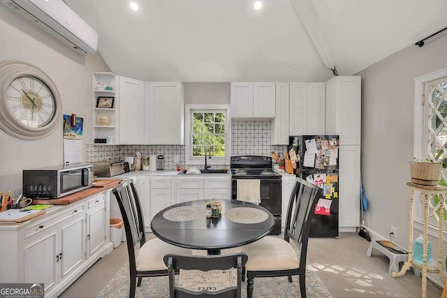 106 Draughons Dr, Saint Simons, GA 31522 - kitchen featuring black appliances, an AC wall unit, backsplash, white cabinets, and recessed lighting