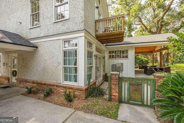 106 Draughons Dr, Saint Simons, GA 31522 - doorway to property featuring a balcony, stucco siding, board and batten siding, and a patio area
