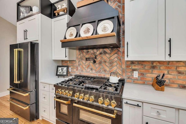 106 Draughons Dr, Saint Simons, GA 31522 - kitchen featuring high quality fridge, range, extractor fan, white cabinets, and decorative backsplash