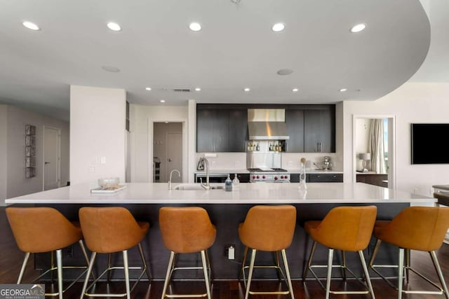 3325 Piedmont Rd NE Unit 2006, Atlanta, GA 30305 - kitchen with wall chimney exhaust hood, light countertops, recessed lighting, a kitchen breakfast bar, and stove
