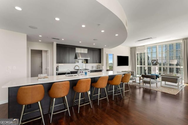 3325 Piedmont Rd NE Unit 2006, Atlanta, GA 30305 - kitchen featuring wall chimney exhaust hood, light countertops, dark wood finished floors, a large island, and modern cabinets