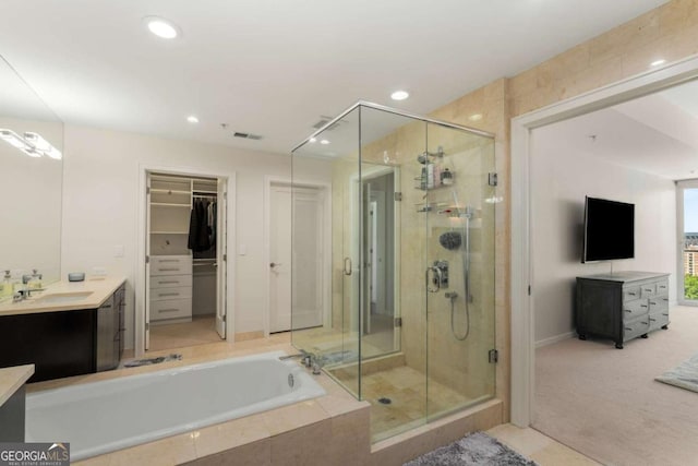 3325 Piedmont Rd NE Unit 2006, Atlanta, GA 30305 - bathroom featuring vanity, a shower stall, a garden tub, recessed lighting, and a spacious closet