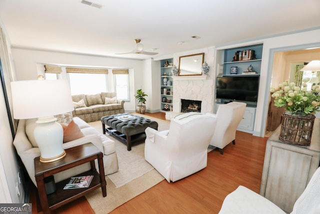 8 Crepe Myrtle, Newnan, GA 30263 - living area with light wood finished floors, a fireplace with raised hearth, and built in shelves