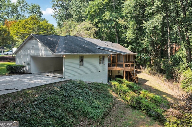 1590 Sunnybrook Farm Rd, Atlanta, GA 30350 - view of home's exterior with concrete driveway, a sunroom, stairway, a carport, and a shingled roof