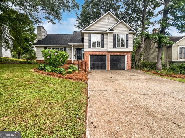 5021 Rodrick Trce, Marietta, GA 30066 - split level home featuring concrete driveway, a chimney, a garage, a front lawn, and brick siding