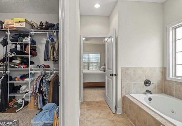 25 Port Richey Way, Brunswick, GA 31523 - bathroom with a tub with jets, ensuite bathroom, tile patterned flooring, and a spacious closet