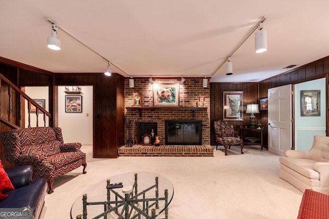 205 Castlegate Rd, Macon, GA 31210 - carpeted living area featuring track lighting, wood walls, a brick fireplace, stairs, and crown molding