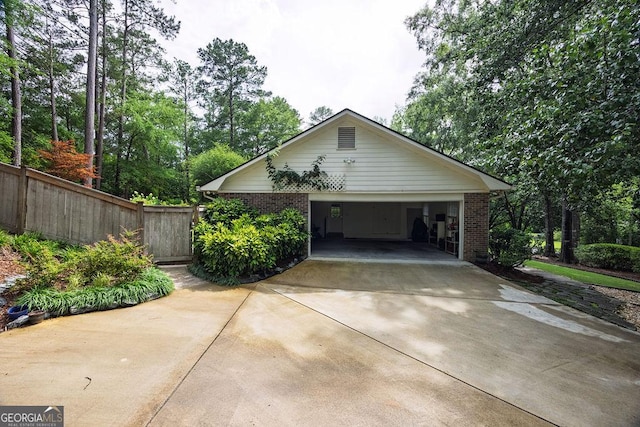 205 Castlegate Rd, Macon, GA 31210 - view of property exterior with brick siding, concrete driveway, a garage, and view of scattered trees