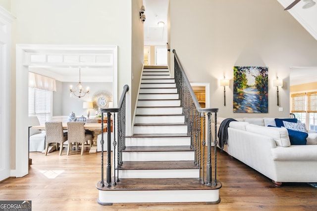 1030 Spring Lake Dr, Bishop, GA 30621 - stairs with healthy amount of natural light, wood finished floors, a chandelier, and crown molding
