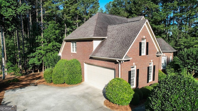 1030 Spring Lake Dr, Bishop, GA 30621 - view of side of property featuring roof with shingles, brick siding, concrete driveway, and an attached garage