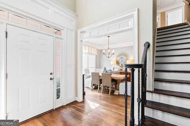 1030 Spring Lake Dr, Bishop, GA 30621 - entryway featuring stairway, wood finished floors, a chandelier, and ornamental molding