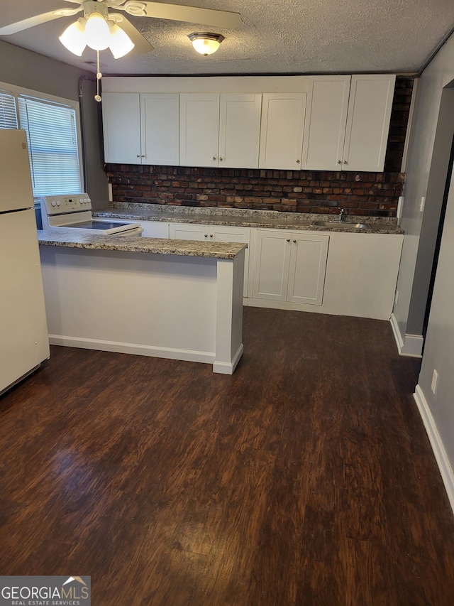3211 Rockview Dr, Lithonia, GA 30038 - kitchen featuring white appliances, white cabinetry, light stone counters, dark wood-type flooring, and a textured ceiling