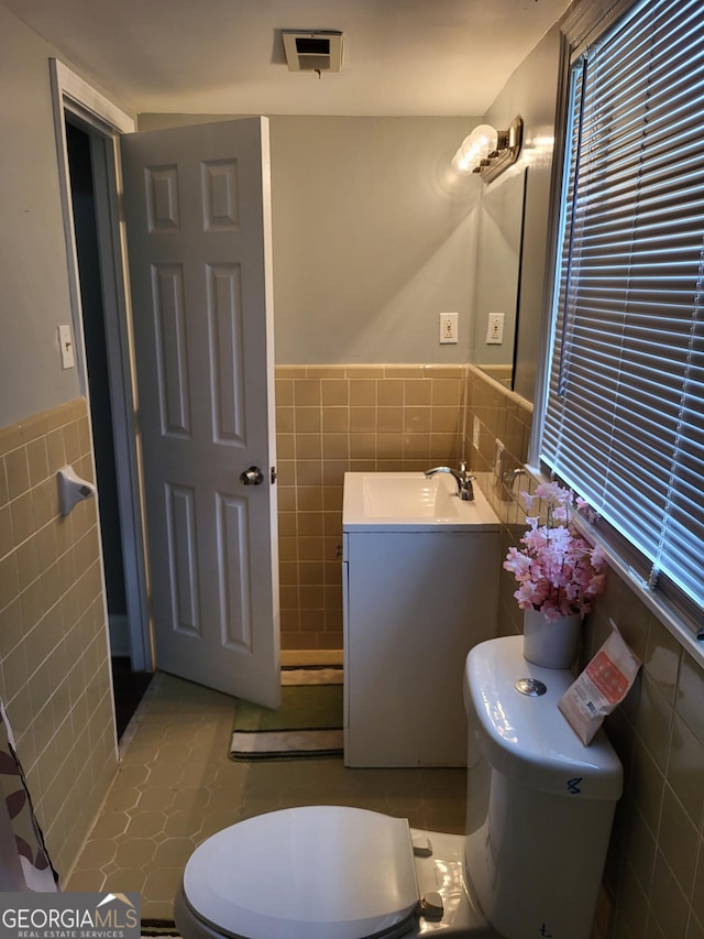 3211 Rockview Dr, Lithonia, GA 30038 - bathroom featuring tile walls, vanity, and a wainscoted wall