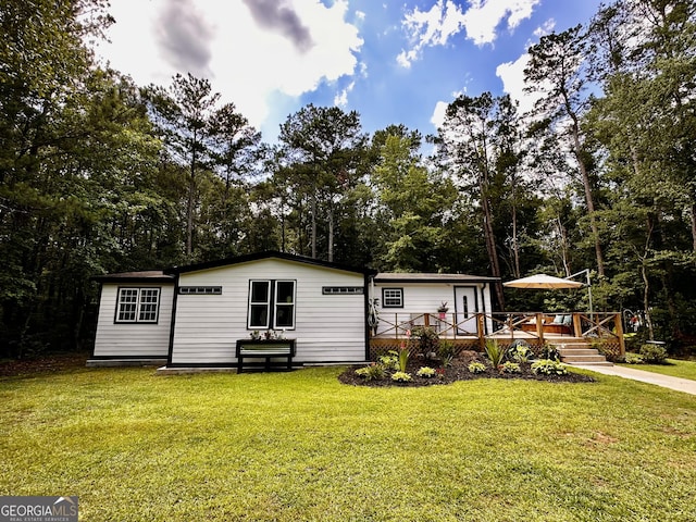 245 Clearwater Rd, Sharpsburg, GA 30277 - view of front of home featuring a wooden deck, a front yard, and view of scattered trees