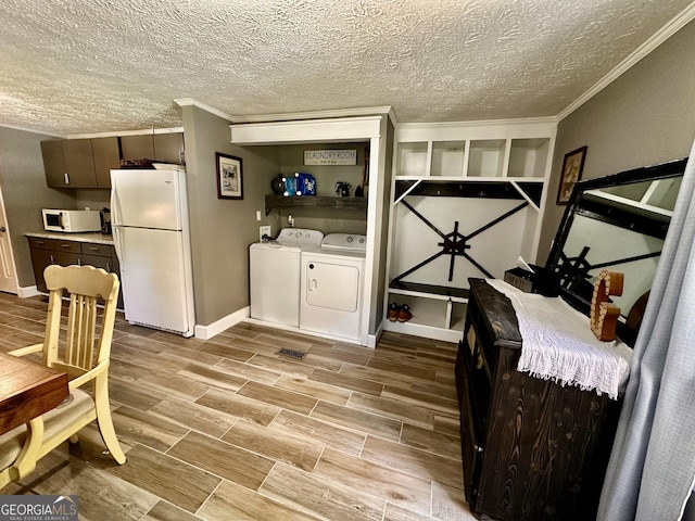 245 Clearwater Rd, Sharpsburg, GA 30277 - interior space with washer and clothes dryer, ornamental molding, a textured ceiling, and light wood-type flooring