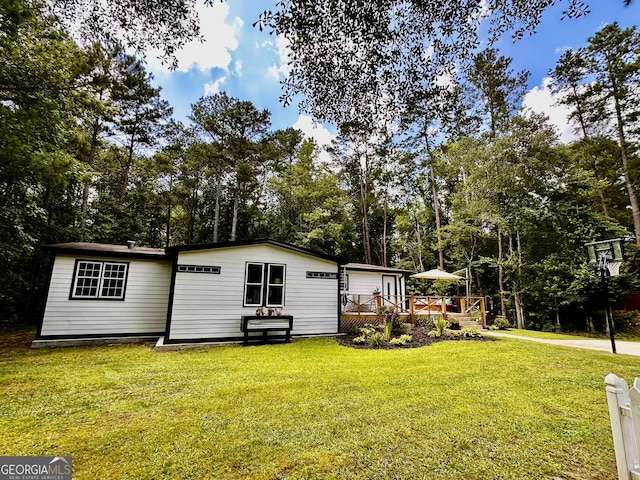 245 Clearwater Rd, Sharpsburg, GA 30277 - view of home's exterior featuring a deck, view of scattered trees, and a lawn