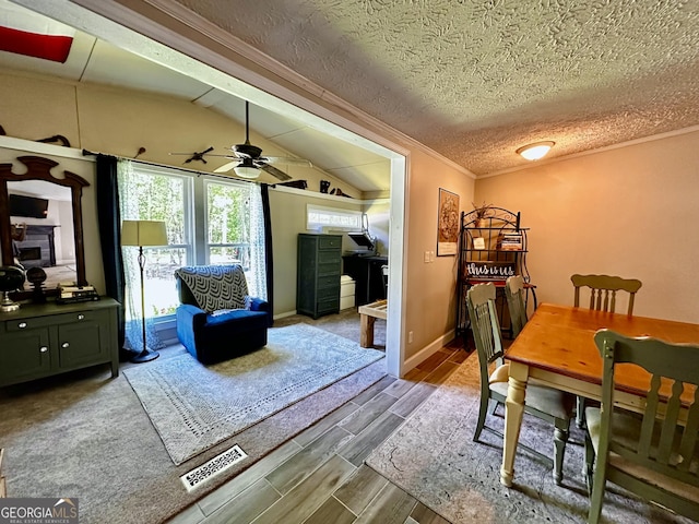 245 Clearwater Rd, Sharpsburg, GA 30277 - dining area with wood tiled floors, crown molding, a ceiling fan, lofted ceiling, and a textured ceiling