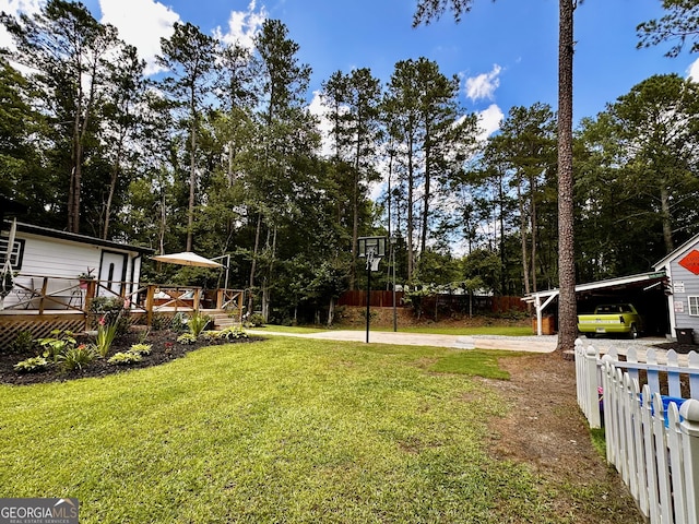 245 Clearwater Rd, Sharpsburg, GA 30277 - view of yard featuring a wooden deck, concrete driveway, and view of scattered trees