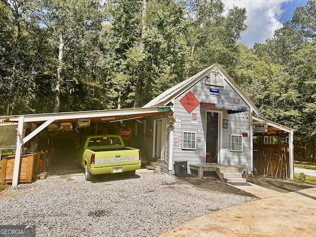 245 Clearwater Rd, Sharpsburg, GA 30277 - view of front facade with a carport, driveway, and view of wooded area