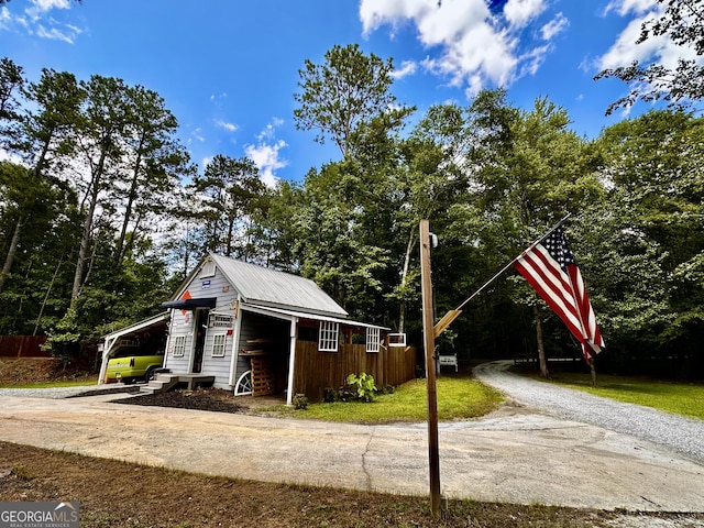 245 Clearwater Rd, Sharpsburg, GA 30277 - view of side of property featuring a metal roof, a carport, and an outbuilding