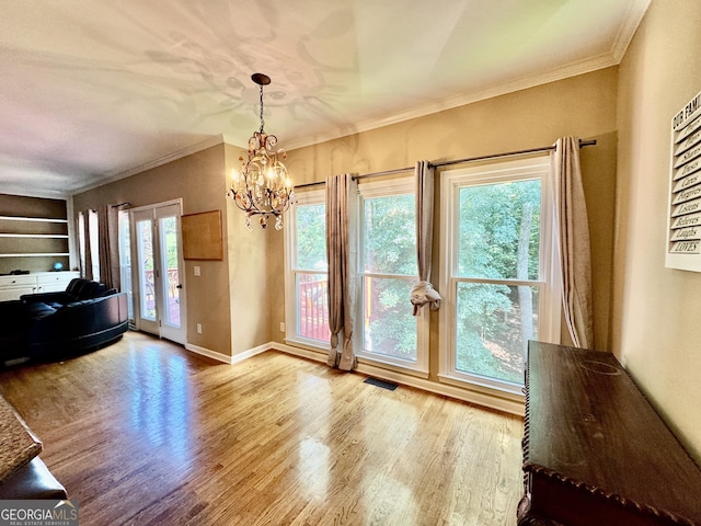 703 Overlook Pt, Woodstock, GA 30189 - dining space featuring wood finished floors, a chandelier, french doors, ornamental molding, and built in shelves