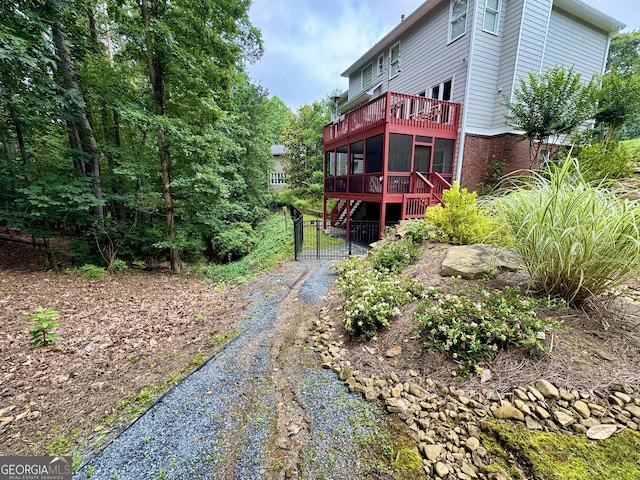 703 Overlook Pt, Woodstock, GA 30189 - rear view of property featuring dirt driveway, a sunroom, and brick siding
