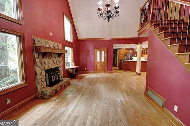 4393 Cannon Rd, Loganville, GA 30052 - unfurnished living room featuring high vaulted ceiling, wood finished floors, plenty of natural light, stairway, and a chandelier